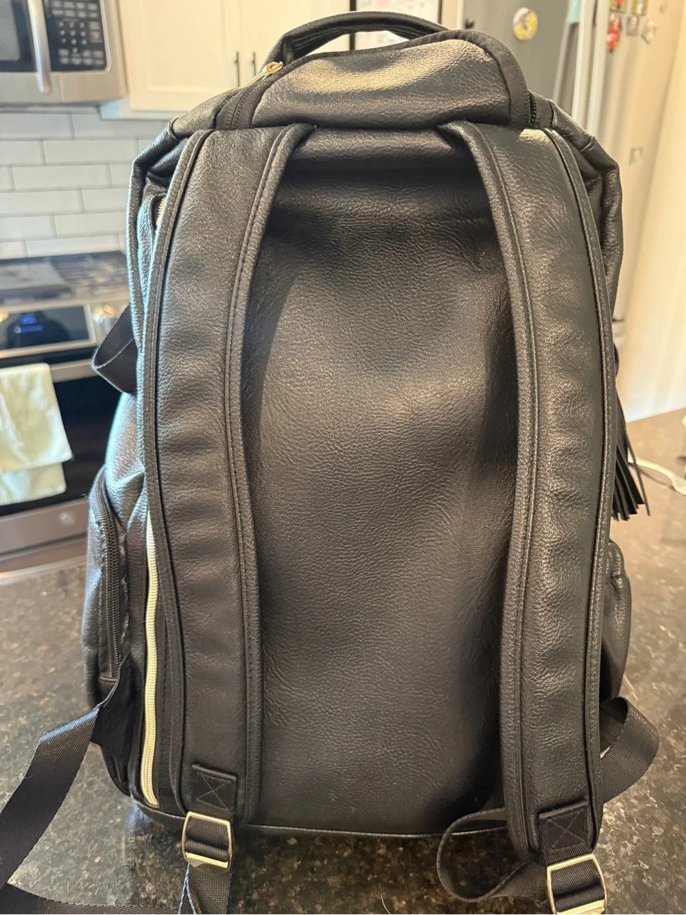Itzy Ritzy Black Quilted Faux Leather Diaper Backpack with Tassel Charm